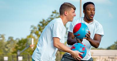 Two students playing sports on campus.